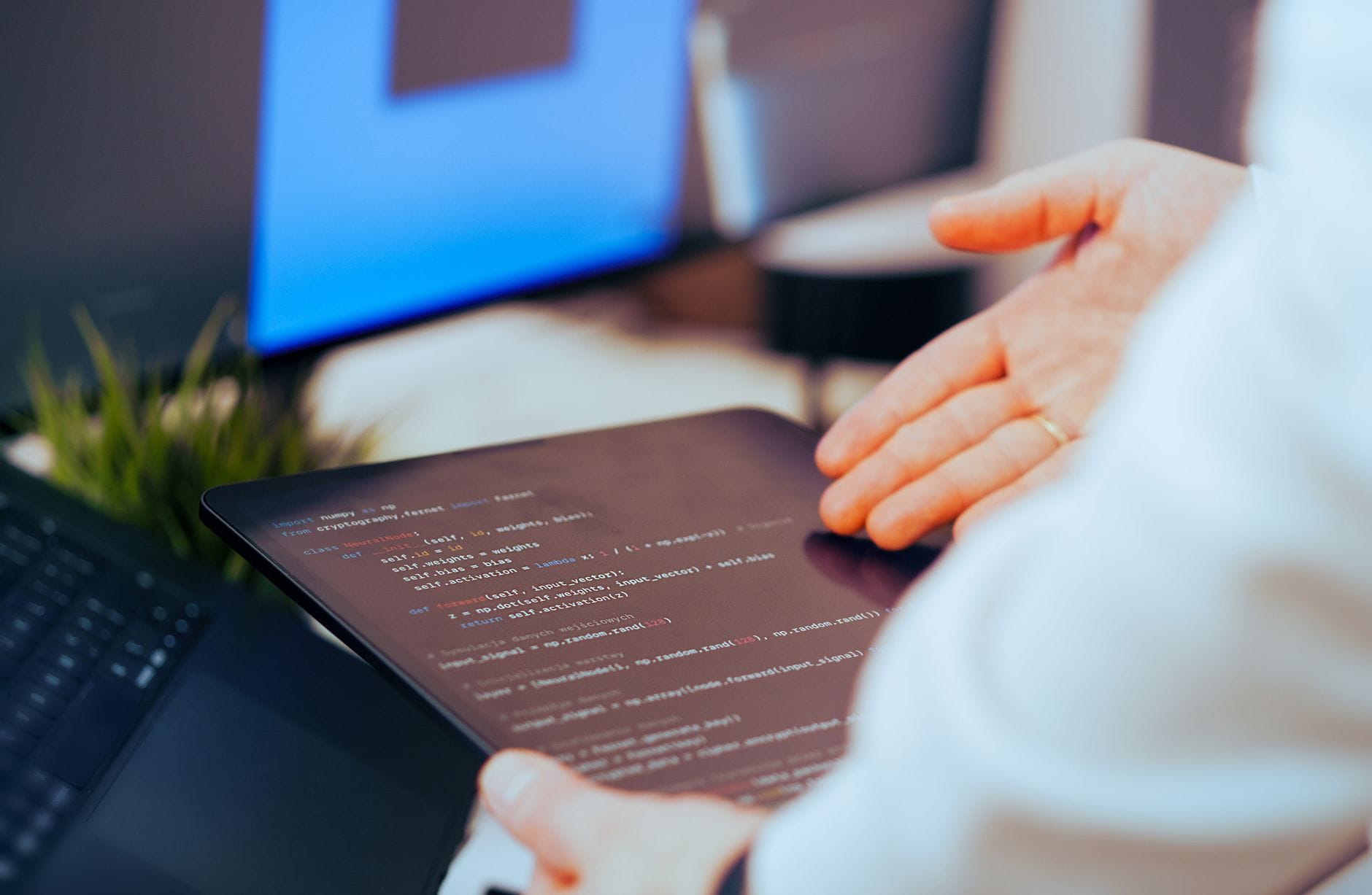 Programista analizuje kod na tablecie w nowoczesnym biurze
