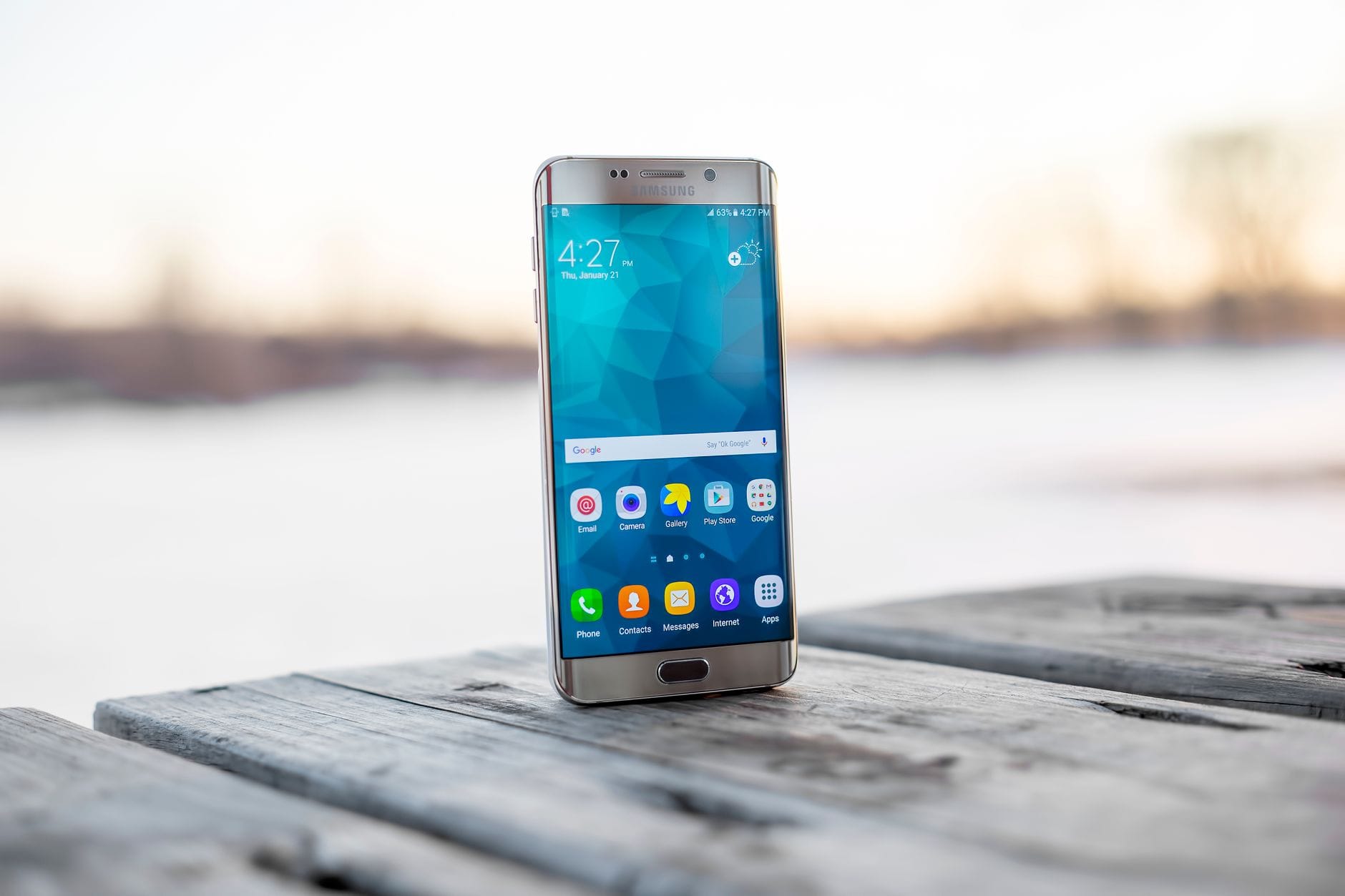 Zakup hurtowy telefonów z UE czy z Chin – co bardziej się opłaca inwestorowi Smartfon Samsung leżący na drewnianej powierzchni o zachodzie słońca