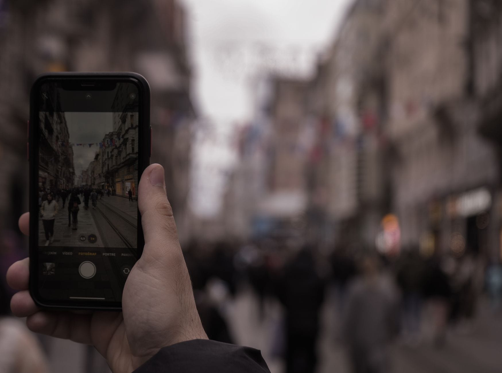Dłoń robi zdjęcie ruchliwej ulicy smartfonem w centrum miasta