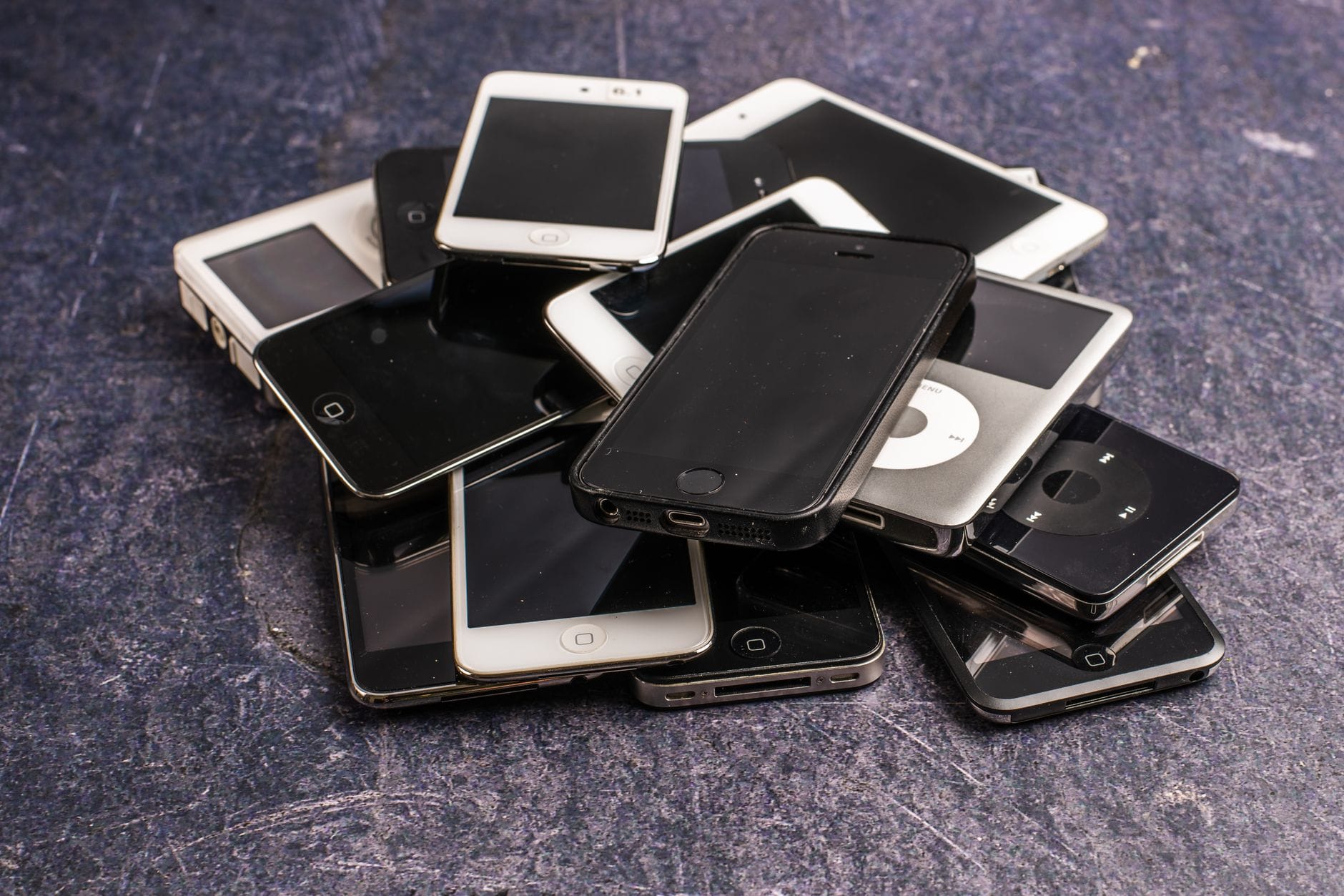 Stos telefonów i odtwarzaczy muzyki na szarym tle