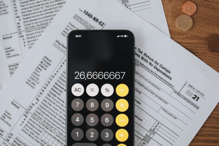 Smartfon i kalkulator na formularzach podatkowych z monetami